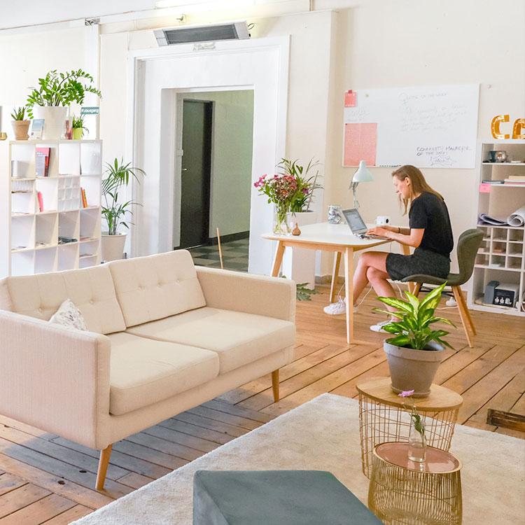 Jeune femme qui travaille depuis chez elle avec son ordinateur portable sur le bureau