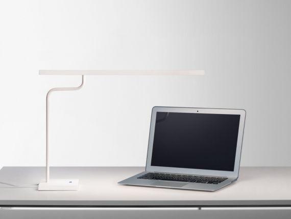 Une lampe blanche et un ordinateur portable sur un bureau